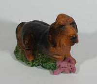 Vintage 1981 Dark Brown Hound Dog Holding Down a Pink Teddy Bear on Grass Collectible Figurine Numbered #714