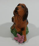 Vintage 1981 Dark Brown Hound Dog Holding Down a Pink Teddy Bear on Grass Collectible Figurine Numbered #714