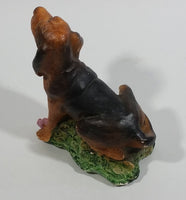 Vintage 1981 Dark Brown Hound Dog Holding Down a Pink Teddy Bear on Grass Collectible Figurine Numbered #714