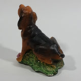 Vintage 1981 Dark Brown Hound Dog Holding Down a Pink Teddy Bear on Grass Collectible Figurine Numbered #714