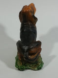 Vintage 1981 Dark Brown Hound Dog Holding Down a Pink Teddy Bear on Grass Collectible Figurine Numbered #714