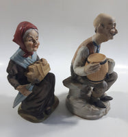 Old Man Sitting With Keg Barrel and Beer Stein and Old Woman Sitting with Umbrella and Packages Porcelain Figurines Set of 2